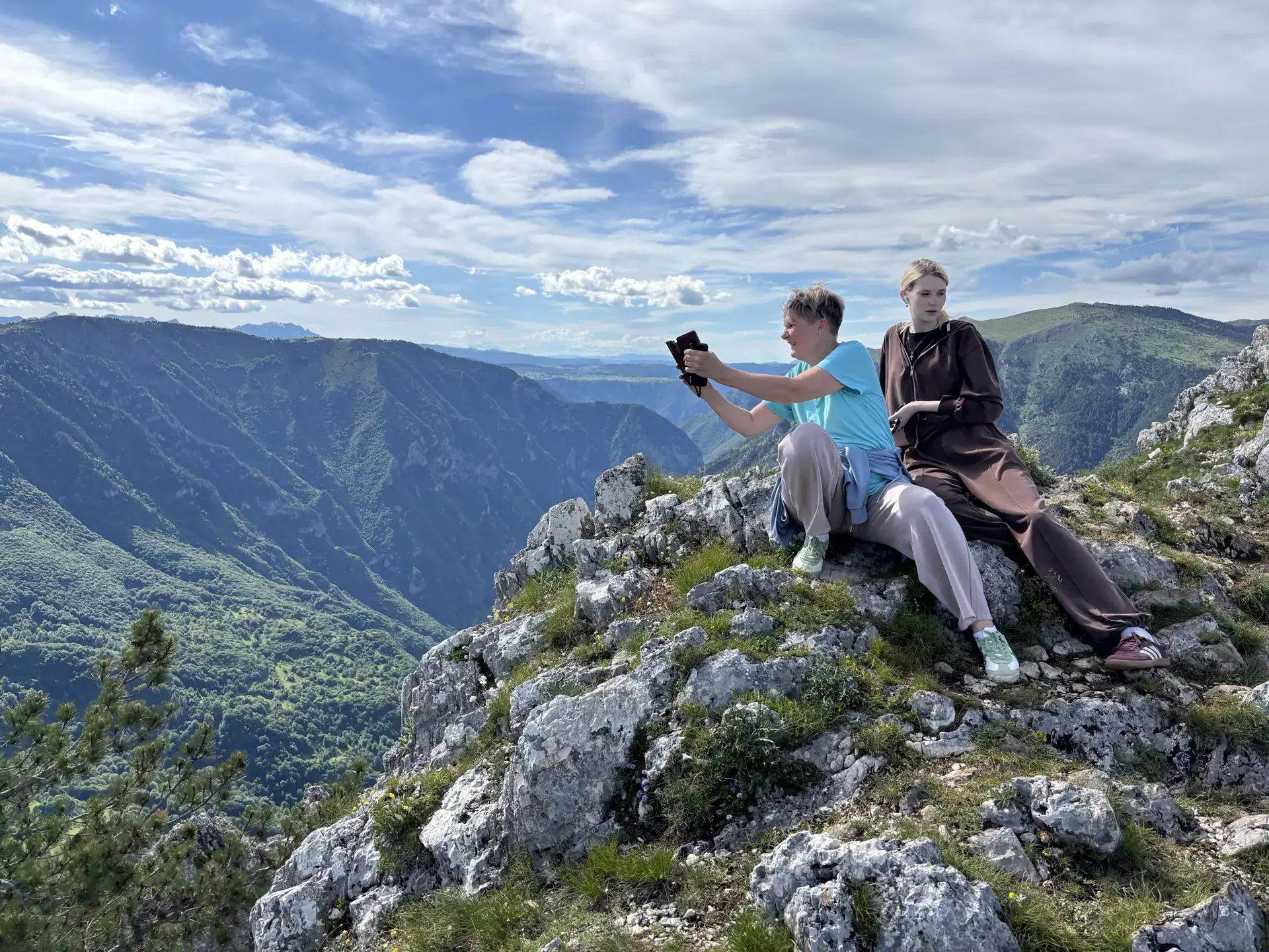 Туристы фотографируются на фоне видов каньона реки Тара